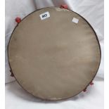 A large old wooden tambourine drum with hand painted floral frieze