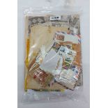 A bag containing a collection of stamps in schoolboy albums, loose and on paper - sold with three