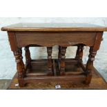 A 62cm q20th Century polished oak coffee table with flanking nesting tea tables, set on turned