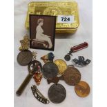 A WWI Queen Mary 1914 Christmas tin containing a quantity of collectable medallions, cap badges,