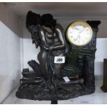 A cast resin figural mantel timepiece in the form of two lovers, with quartz movement