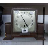 A vintage stained oak cased mantel clock with Clarion eight day chiming movement - bearing