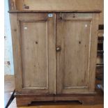 A 90cm old stripped pine cupboard with part folding-top and pair of panelled doors under, set on