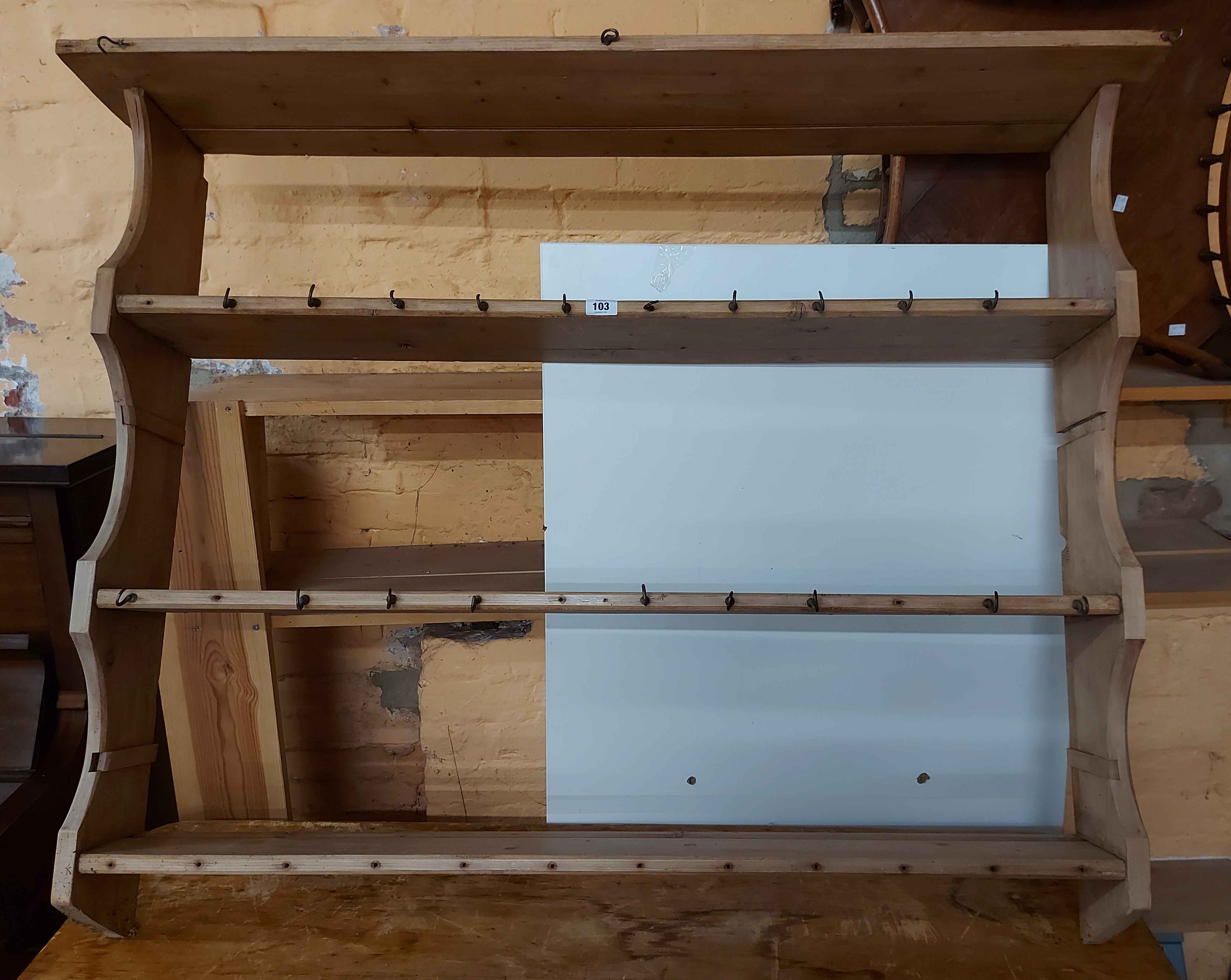A 1.33m old stripped pine wall mounted three shelf open plate rack with numerous cup hooks