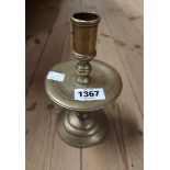 An antique cast brass candlestick with straight sconce, disc form drip tray and domed foot