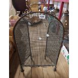 A brass framed and mesh folding firescreen