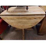 An 87cm vintage stripped oak oval topped drop-leaf dining table, set on quadruple shaped supports