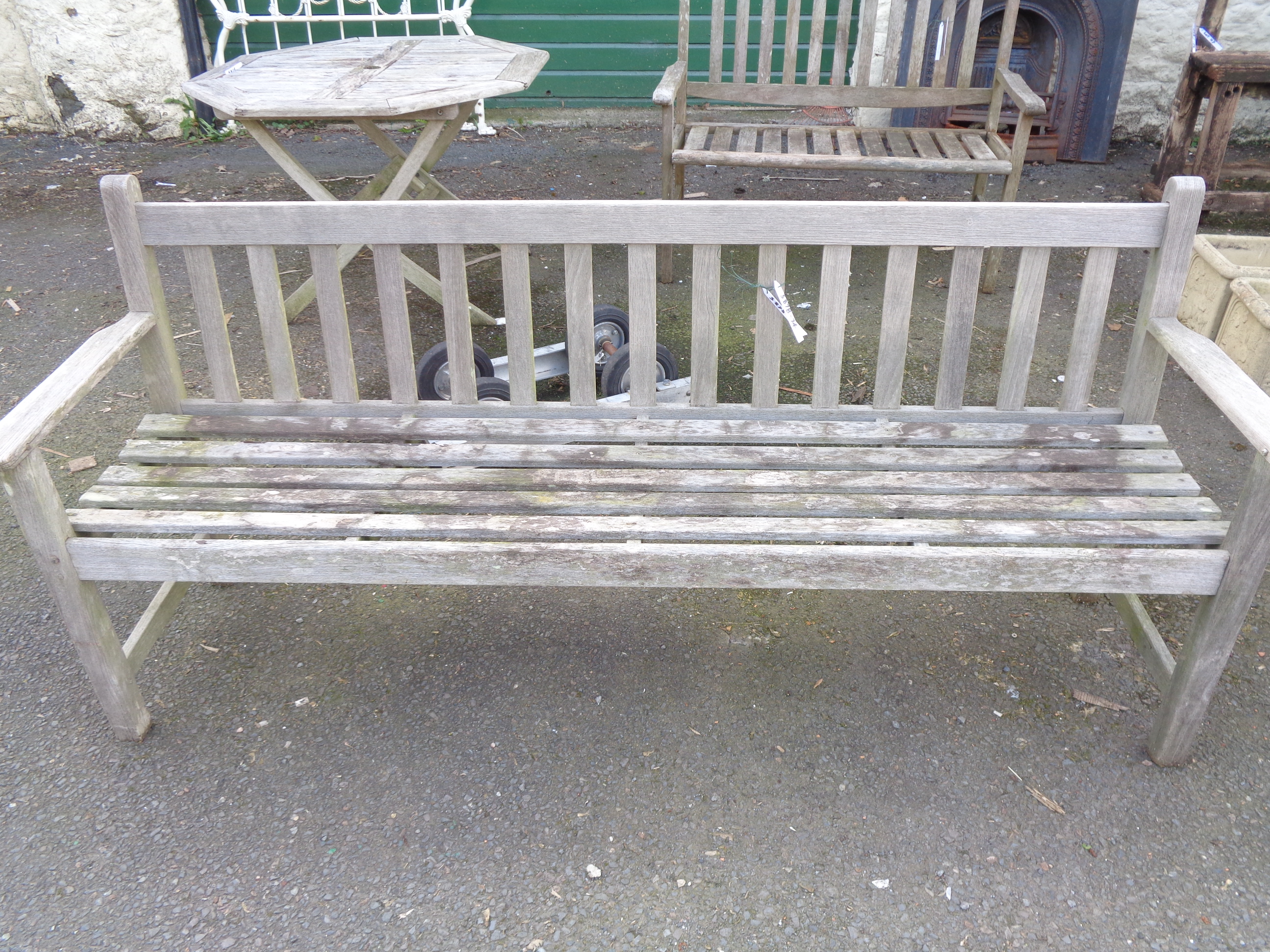 A teak garden bench of slatted form