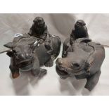 A pair of antique Chinese carved wooden figurines, each depicting a water buffalo and driver -