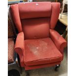 A modern wing back armchair upholstered in burgundy velour, set on cabriole front legs with pad