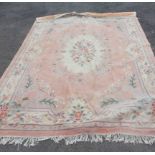 A large Chinese washed wool rug/carpet with rose floral decoration and swags on a peach ground - 3.