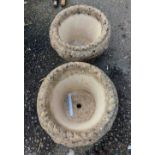 A pair of circular concrete garden pots with moulded leaf decoration