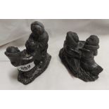 A pair of cast resin figurines of Innuit carving style