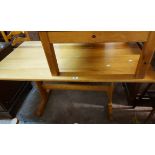 A 1.37m modern pine refectory style dining table, set on shaped standard ends with uniting