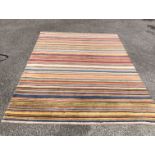 A modern John Lewis handmade wool rug with multicoloured striped decoration on a russet ground - 2.