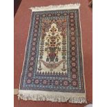 A small handmade rug with central floral vase pattern and geometric border - 1.20m X 73cm