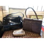 A box containing three vintage handbags comprising a Waldybag black patent leather example with