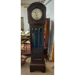 A vintage stained wood longcase clock with glazed trunk door, visible pendulum and spring driven
