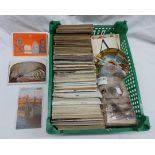 A crate containing a collection of early 20th Century postcards and many later examples including