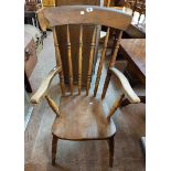 An old Windsor high spindle back elbow chair with moulded solid elm seat, set on ring turned