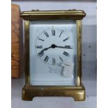 An old brass and bevelled glass cased carriage timepiece with dial marked for Squire & Son.,