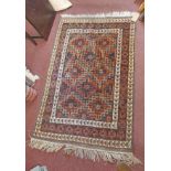 A handmade rug with central repeat medallion pattern and wide border - 1.53m X 1m