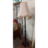 A vintage stained wood standard lamp, set on turned and fluted pillar and circular base - with light