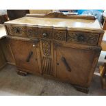 A 1.21m vintage oak serpentine front sideboard with moulded and carved decoration, three frieze