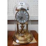 A vintage Kundo brass anniversary clock with ball pendulum under perspex dome