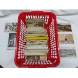 A red crate containing a collection of early 20th Century and later postcards including Australia,