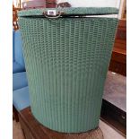 A vintage Lloyd Loom corner laundry basket with later green painted finish