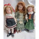 Three modern porcelain headed costume dolls with stands