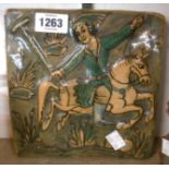 A Persian ceramic tile with relief moulded decoration depicting a polo player