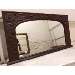 A 95cm late Victorian carved oak framed overmantel mirror with arched top plate