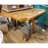 A 1930's figured walnut veneered and cross banded tilt-top table, set on slender standard ends