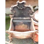 An antique cast iron fire basket with ornate scroll decoration to back, set on cabriole legs with