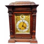 An antique German ornate carved oak cased table clock with regulator dial and brass spandrels to