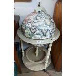 A modern globe pattern drinks cabinet with printed map decoration and shaped undertier, set on