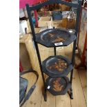 A Japanese black lacquered three tier folding cake stand with gilt decoration depicting birds and