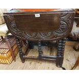 A 61cm vintage stained oak gateleg dining table with carved decoration, set on bobbin turned