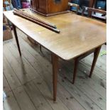 A 1.47m mid 20th Century teak and afromosia extending dining table with stowed leaf, set on