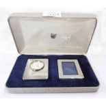 A cased silver fronted small quartz timepiece and photo frame, both with upholstered easel backs