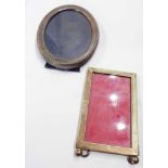 A silver fronted oval photograph frame with upholstered easel back - sold with a plated similar