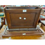 A vintage oak magazine rack - sold with a set of three graduated tea trays with flanking chrome