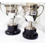 A pair of 16.5cm silver trophy cups with flanking cast acanthus scroll handles, set on matching