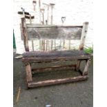 A rustic style oak garden bench of plank form