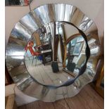 A 98cm diameter modern wall mirror with wavy chromed border and bevelled plate