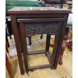 A nest of two Chinese stained hardwood tea tables with carved flowering branch decoration, set on