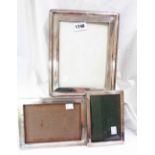 A silver fronted photograph frame with oak easel back - to take 20cm X 16cm - sold with two others