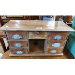 A 50cm vintage pine desk tidy in the form of a pedestal desk with central drawer, six flanking